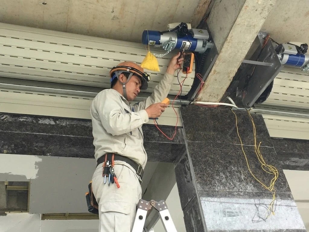 Thợ Saovietdoor dùng đồng hồ đo kiểm tra motor cửa cuốn